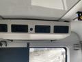 Interior view of a 2018 Chevrolet Express showing the ceiling mounted air conditioning unit with multiple vents and a blue indicator light