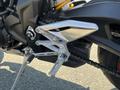 A close-up of a 2018 Triumph Street Triple RS's footpeg and gear shifter with sleek silver metal and black components showcasing a sporty design