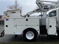 A 2013 International DuraStar utility truck with an Altec aerial lift attached and several compartments for tools and equipment on the side