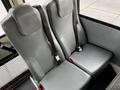 Two gray passenger seats with seatbelts in an interior setting