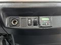 A close-up view of the dashboard controls in a 2019 Hino 338 featuring a power outlet switch and a digital display control unit