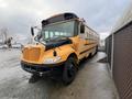 A 2009 International 3000 school bus in yellow with black accents and a large windshield parked in a lot