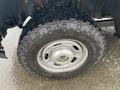 A close-up of a rugged tire mounted on a silver wheel of a 2017 Ford F-250 SD showcasing a thick tread pattern designed for off-road driving