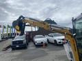 A yellow 2024 AGT Industrial H13R Mini Excavator with a large black digging bucket attached to its articulated arm
