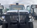 A 2016 International 7400 truck with a front-mounted snow plow and dual headlights