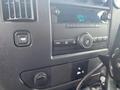 A car dashboard featuring a radio display with buttons and knobs for audio control in a 2014 Chevrolet Express