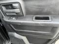 Interior door panel of a 2015 RAM 1500 featuring a door handle window controls and a small storage compartment