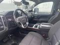 Interior view of a 2015 GMC Sierra 1500 showcasing the driver's seat dashboard and center console with a gear shift and storage compartment