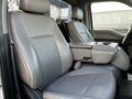 The interior of a 2018 Ford F-550 featuring two leather seats with a center console in between and a simple layout
