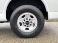 A wheel of a 2014 GMC Savana featuring a silver rim and black tire with visible tread pattern