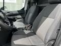Two gray upholstered front seats inside a 2016 Ford Transit Connect with a steering wheel and dashboard visible in the front cabin area