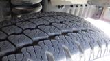 Close-up of a tire from a 2011 Ford Econoline showing detailed tread pattern and texture