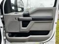 Interior door panel of a 2020 Ford F-350 SD featuring gray and black accents with a speaker and storage compartment