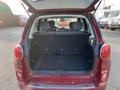 The rear interior of a 2015 Fiat 500L with the trunk open showing the empty cargo space and back seats in an upright position