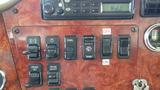 Dashboard of a 2003 International 5600i featuring various switches including edge light panel wash and cruise control buttons