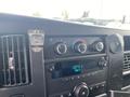 Dashboard controls of a 2014 Chevrolet Express showing air conditioning dials and a radio display