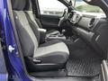 A 2022 Toyota Tacoma interior features two front seats with gray fabric upholstery a console with gear shifter and various controls and a rubber floor mat