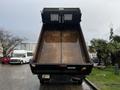 A 2021 Ford F-550 dump truck with its bed in an elevated position ready for unloading