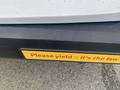 A yellow bumper sticker on a vehicle that reads Please yield its the law attached to a 2018 Chevrolet Express