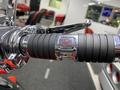 Close-up of the grip and control switch on a 2024 Harley Davidson Fat Boy motorcycle featuring chrome details and a black rubber grip