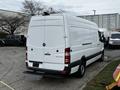 A white 2016 Mercedes-Benz Sprinter van with a rear cargo door and black step at the back