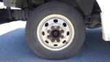 Close-up of a tire on a 2006 Ford Econoline revealing a silver wheel with multiple lug nut holes and a black tire tread