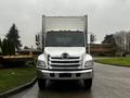 A white 2020 Hino 338 box truck facing forward with a silver grille and multiple orange clearance lights on the roof