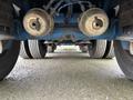 Underneath a 2011 Freightliner Cascadia Nordic showing the undercarriage with brake drums and multiple tires aligned in a row