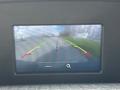 Rearview camera display showing guidelines for parking with a view of a road ahead
