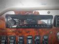 A Pioneer car stereo and various control buttons on a wooden dashboard inside a 2013 International 5900i truck