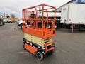 A 2024 JLG R1932 scissor lift with an orange and beige platform raised above a black base equipped with wheels for mobility