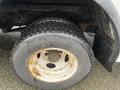 A close-up of a worn tire on a 2012 Ford Econoline showing visible rust on the rim and tread wear on the tire