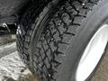 Close-up of a 2019 Hino 338 vehicle tire showcasing deep tread patterns and white rim with dirt and debris visible on the tire surface