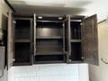 A dark wood cabinet with four open doors revealing empty shelves inside