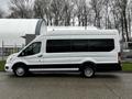 A 2021 Ford Transit van in white with black accents, featuring large windows and a high roof, parked on a concrete surface