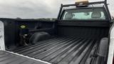 A 2013 Chevrolet Silverado 1500 with an empty truck bed showing a black liner and a mounting bracket on the left side