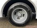 A silver alloy wheel with a tire featuring a tread pattern mounted on a 2017 Chevrolet Express