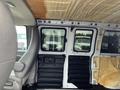 Interior view of a 2012 Chevrolet Express van showing front seats and side doors with insulation on the walls