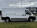 A white 2021 RAM Promaster van with a high roof and no visible windows on the side standing on a paved surface