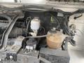 A close-up view of the engine compartment of a 2012 Ford Econoline showing the engine components and fluid reservoirs