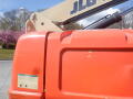 A 2008 JLG Boom Lift with an orange body and a beige arm extended upward