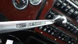 A chrome gear shift lever with a label reading NOT FOR PARKING in a truck's interior featuring various gauges and control switches