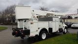 A white 2005 International 4300 bucket truck equipped with a utility platform and storage compartments on the side