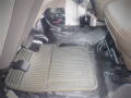 A gray rubber floor mat labeled Super Duty in a 2008 Ford F-550 cab area with visible footwell components and carpeted surface underneath the mat