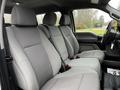 Interior of a 2020 Ford F-350 SD with gray fabric seats in the front row featuring seat belts and a spacious layout