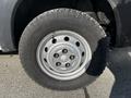 A silver wheel with multiple holes and a rugged tire designed for a 2017 RAM Promaster