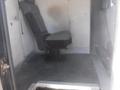 Interior view of a 2016 Ford Transit showing a single gray driver's seat mounted on a black platform with a textured floor