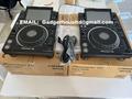 Two Pioneer CDJ-3000 DJ turntables positioned on cardboard boxes with cables and additional equipment nearby