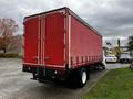 A red 2008 Ford F-750 box truck with a white cab and a large cargo area featuring vertical metal latches on the rear doors