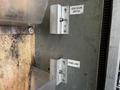 Close-up of two metal switches labeled Side Door Switch and Dome Lamp mounted on a gray surface
